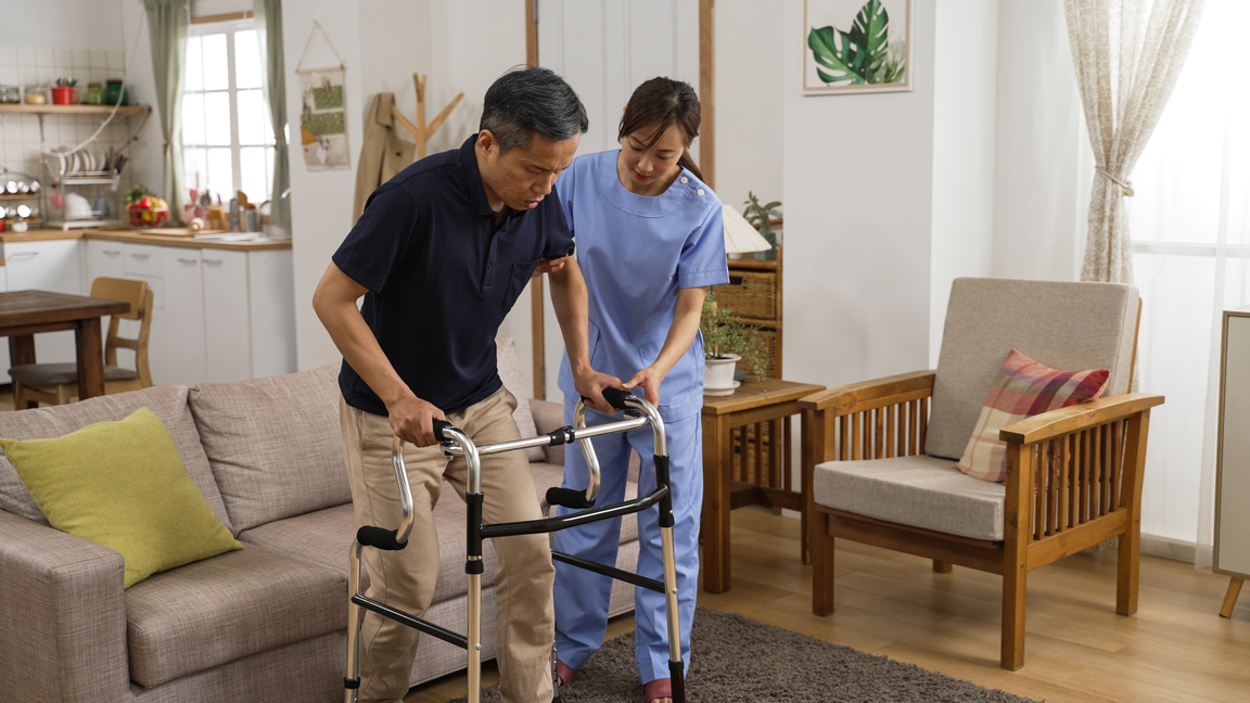 Asian Senior Stroke Patient Undergoing Rehab Exercise with a Wal